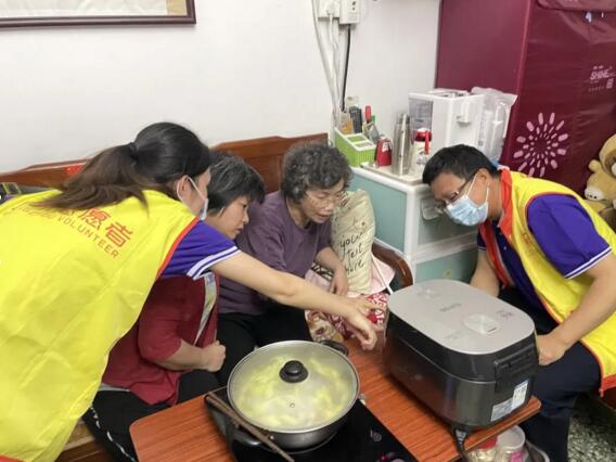 佳都黨員為小何講解給她帶去的智能電飯煲的用法